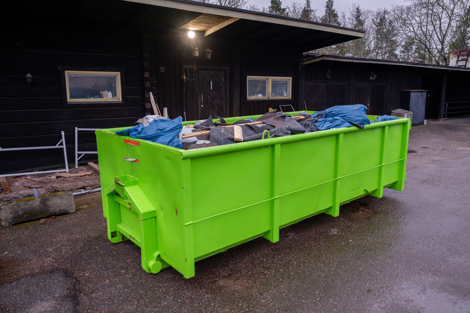 Bright green dumpster filled with construction debris