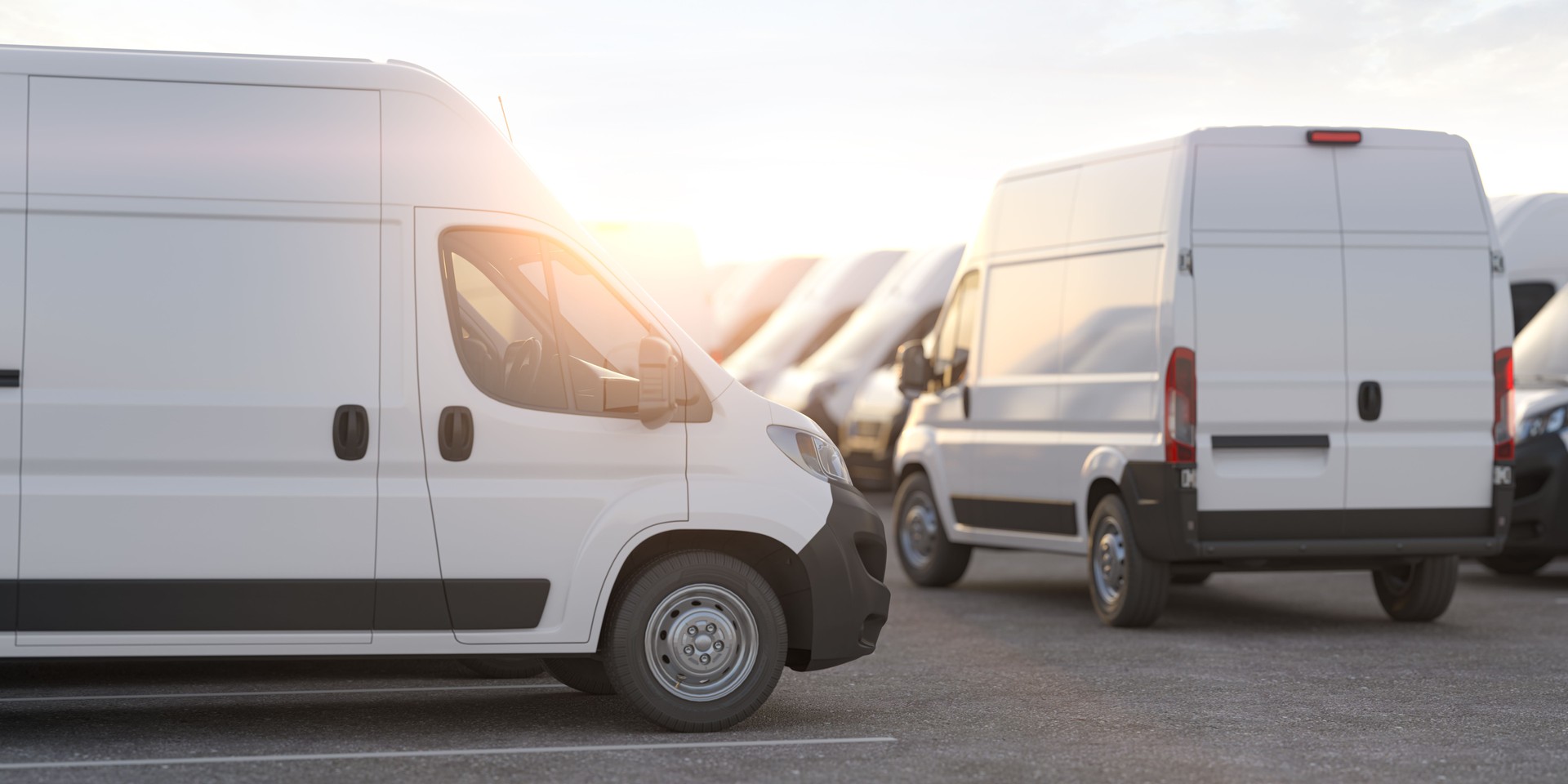 Express delivery, shipping service concept. Delivery vans in a row in the rays of sunset or dawn.